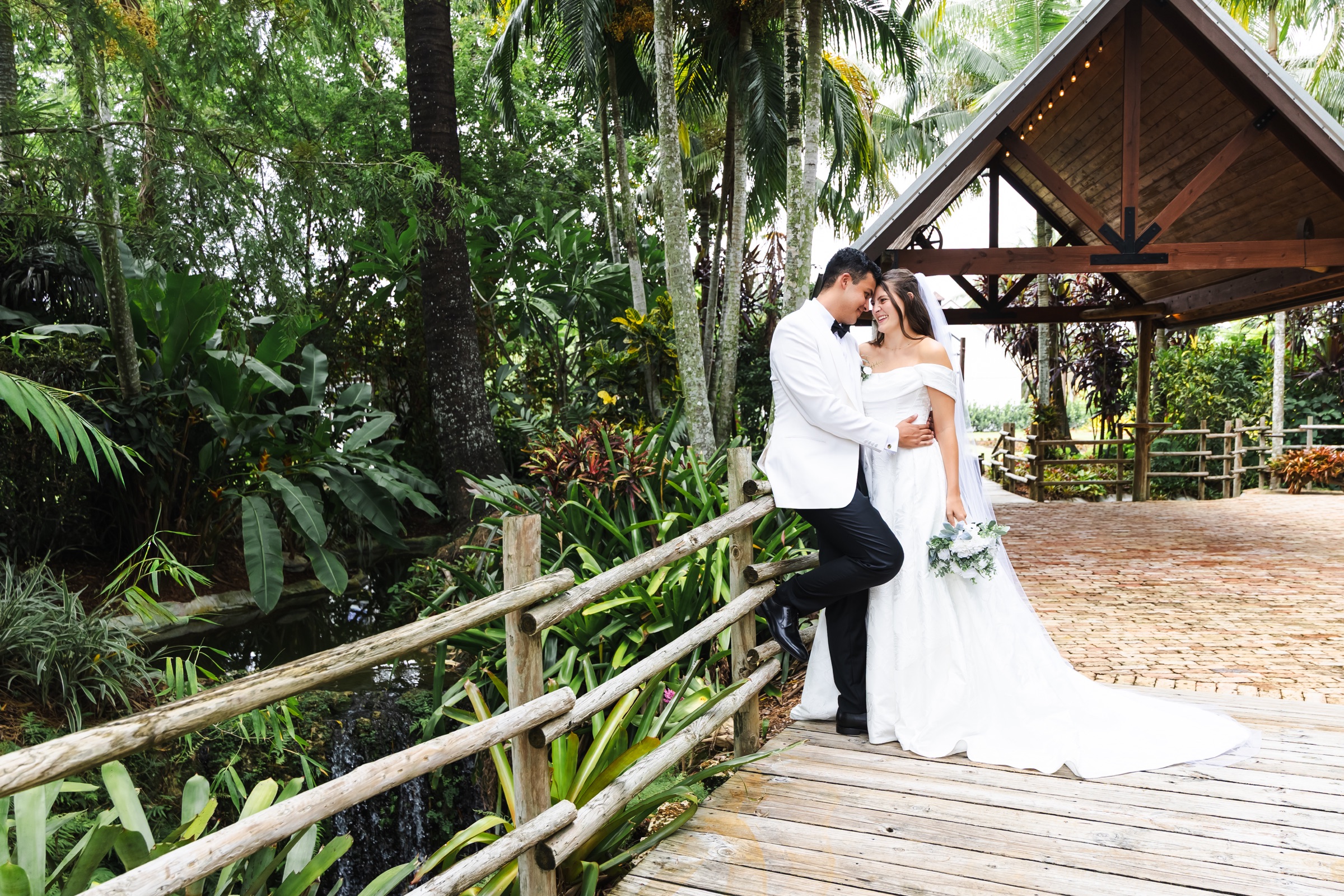 Newlyweds together beside a tropical wedding pavilion